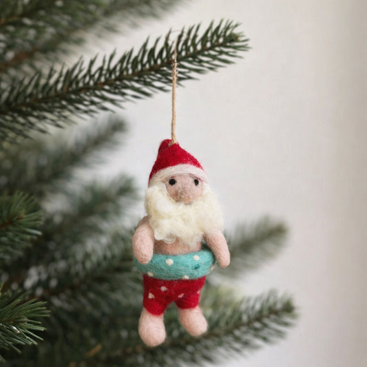 Needle felted Santa Claus ornament with light blue swim ring hanging on a Christmas tree branch.